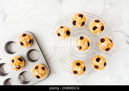 Muffins aux cerises sous forme de métal argenté et sur la grille de refroidissement sur marbre blanc.Vue de dessus.Version horizontale. Banque D'Images