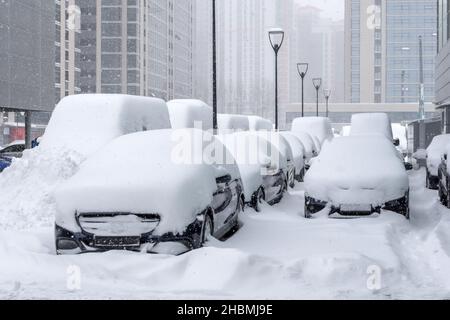 De nombreuses voitures garées dans le quartier des affaires de la ville pendant une tempête de neige. Banque D'Images