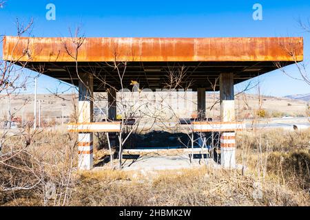 Rusty abandonné station-service construction par la route avec voiture de passage dans l'arrière-plan.Industrie du carburant et lieux abandonnés en Turquie.2019 Banque D'Images