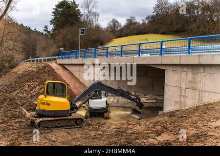 La pelle hydraulique ajuste le terrain autour du nouveau pont.Achèvement des travaux de construction d'un pont sur une route de campagne en République tchèque. Banque D'Images