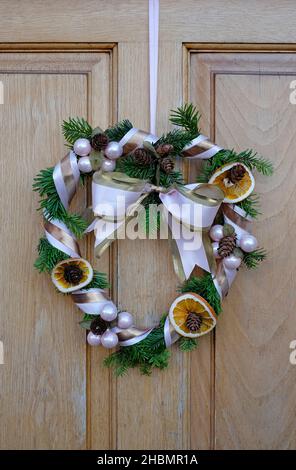 couronne de noël suspendue à la porte d'entrée de la maison, norfolk, angleterre Banque D'Images
