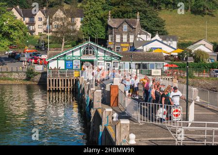 Les touristes du Lake District, vue en été des gens sur Ambleside Pier faisant la queue pour un bateau de visite pour les emmener sur une croisière du lac Windermere, Cumbria, Royaume-Uni Banque D'Images