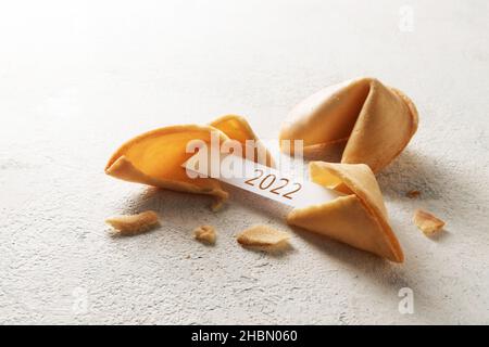 les cookies de fortune chinois, on est craqué avec le papier slip montrant le nouvel an 2022 sur un fond clair avec l'espace de copie, la mise au point sélectionnée, la profondeur étroite de Banque D'Images
