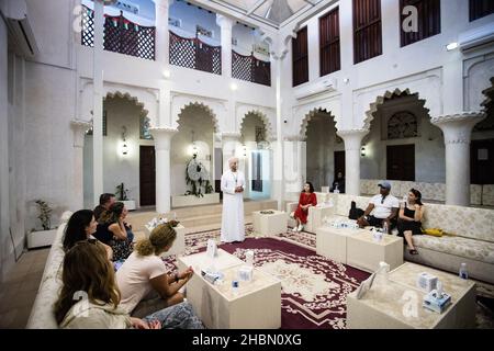 Les touristes boivent un café avec un guide local à l'intérieur du musée Dar Al Nadwa dans la ville de Dubaï, aux Émirats arabes Unis. Banque D'Images