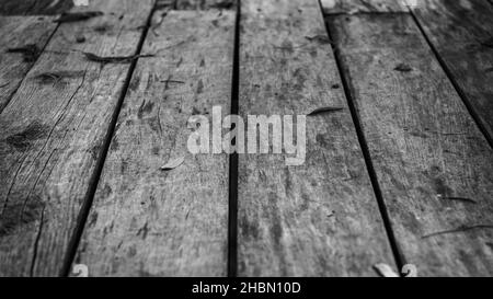 de vieilles planches de bois et des feuilles tombées sur elles et des clous rouillés aux extrémités des planches, qui sont cloués à la base Banque D'Images