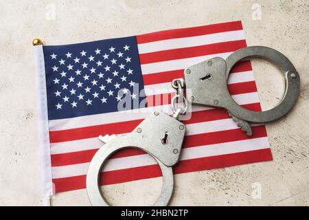 Drapeau des États-Unis et menottes sur un fond abstrait, le concept de crime dans la société américaine Banque D'Images