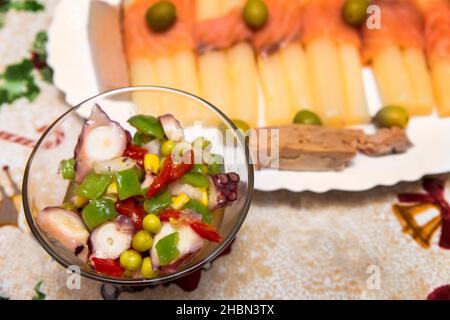 bol en verre avec salade multicolore de poulpes, petits pois et poivrons Banque D'Images