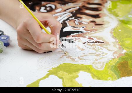 Femme peint sur toile.Main de femme tenant une brosse pour dessiner un gros plan Banque D'Images