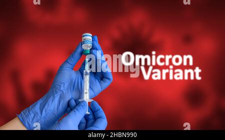 Travailleur médical avec gants bleus tenant la seringue et extrayant le vaccin coronavirus du flacon devant le fond rouge avec le texte omicron sars-cov-2 Banque D'Images