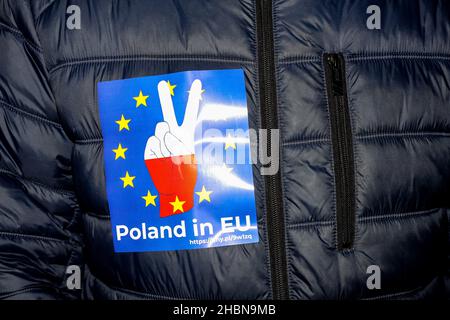 Cracovie, Pologne.19th décembre 2021.Un autocollant avec une main aux couleurs nationales polonaises, un drapeau de l'UE et une inscription « la Pologne dans l'UE » est visible sur le blouson d'un manifestant.le Parlement polonais a récemment adopté une loi controversée qui empêcherait les entreprises étrangères de posséder de grandes entreprises médiatiques polonaises,Ce qui pourrait forcer le groupe de médias américain Discovery à vendre sa participation dans le plus grand diffuseur privé de Pologne, TVN.Des milliers de Polonais ont commencé à protester contre cette politique dans toutes les grandes villes.(Photo de Filip Radwanski/SOPA Images/Sipa USA) crédit: SIPA USA/Alay Live News Banque D'Images