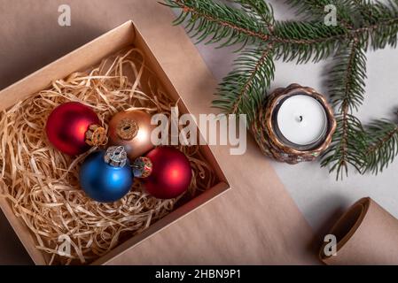 Emballage d'un cadeau de Noël et du nouvel an dans des matériaux écologiques : papier kraft, branches de sapin vivant, cône, ficelle.Étiquettes avec maquette, décor naturel Banque D'Images