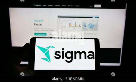 Personne tenant un téléphone portable avec le logo de la société américaine d'analyse du cloud Sigma Computing Inc. À l'écran devant la page Web.Mise au point sur l'affichage du téléphone. Banque D'Images