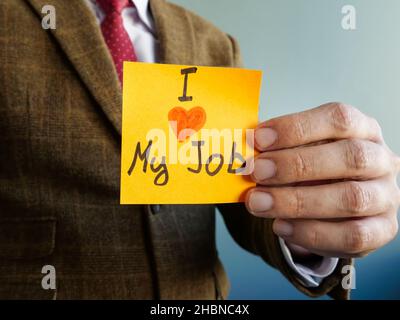 L'homme montre signe J'aime mon travail.Concept de satisfaction des employés. Banque D'Images