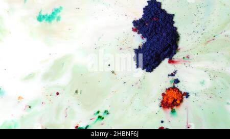 Fond coloré avec substance laiteuse et encres bleu vif et sec flottant dessus.Vue de dessus des peintures en poudre sèches colorées sur la surface du liquide blanc Banque D'Images