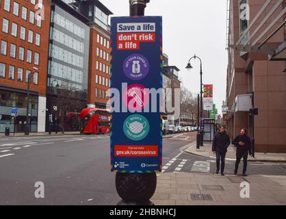 Londres, Royaume-Uni 18th décembre 2021.De nouveaux panneaux « Save A Life, Don't Risk A Life » exhortant tout le monde à se faire vacciner, à se faire tester et à porter un masque ont été installés dans le centre de Londres comme la variante Omicron de la propagation COVID-19 au Royaume-Uni. Banque D'Images