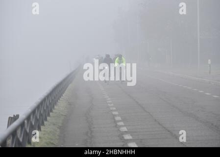 Milan, Lombardie, Italie.19th décembre 2021.Décembre 19, Milan, Lombardie, Italie: Les cyclistes sont vus dans le brouillard épais à côté de Naviglio Grande, qui est un canal d'eau qui traverse la ville crédit: Ervin Shulku/ZUMA Wire/Alay Live News Banque D'Images