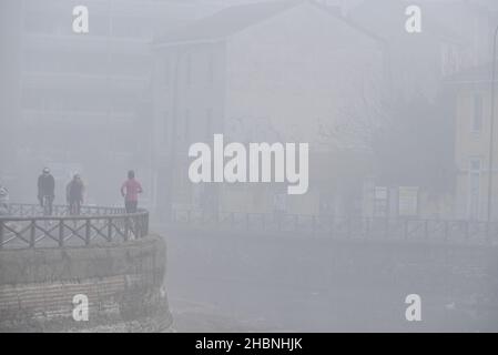 Milan, Lombardie, Italie.19th décembre 2021.Décembre 19, Milan, Lombardie, Italie: Des cyclistes et une femme de jogging sont vus à côté de la Naviglio Grande pendant le brouillard épais crédit: Ervin Shulku/ZUMA Wire/Alamy Live News Banque D'Images