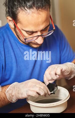 maintenance de l'imprimante à jet d'encre. technicien chargé du nettoyage et de la maintenance de la tête avec un coton-tige. Banque D'Images