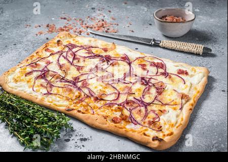 Tarte traditionnelle allemande de Flamkuchen avec jambon et oignon.Arrière-plan gris.Vue de dessus Banque D'Images