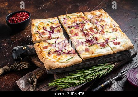 Tarte flamandes avec fromage à la crème, bacon et oignons.Flamkuchen de la région Alsace.Arrière-plan sombre.Vue de dessus Banque D'Images