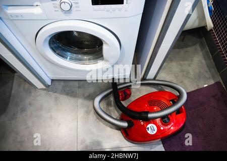 POZNAN, POLOGNE - 10 mai 2019 : vue de dessus d'un aspirateur Bosch rouge à côté d'un lave-linge de marque Beko Banque D'Images