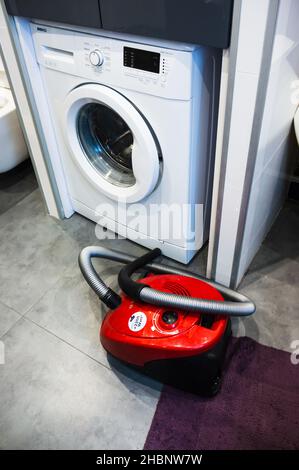 POZNAN, POLOGNE - 10 mai 2019 : un aspirateur Bosch rouge à côté d'un lave-linge de marque Beko Banque D'Images