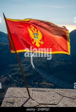 Flopping dans le vent au parc national de Lovcen, se tenant fièrement dans les couleurs rouge et or à côté du Mausolée de Njegos, une destination touristique importante et res Banque D'Images