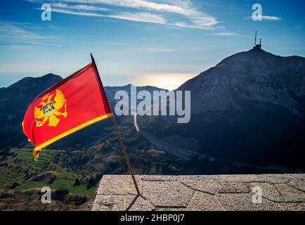 Flopping dans le vent au parc national de Lovcen, se tenant fièrement dans les couleurs rouge et or à côté du Mausolée de Njegos, une destination touristique importante et res Banque D'Images