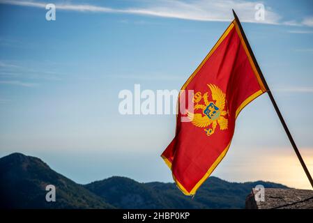 Flopping dans le vent au parc national de Lovcen, se tenant fièrement dans les couleurs rouge et or à côté du Mausolée de Njegos, une destination touristique importante et res Banque D'Images