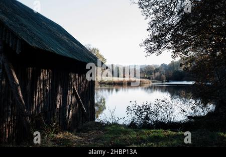 lodge en bois à côté d'un lac paisible dans la campagne Banque D'Images