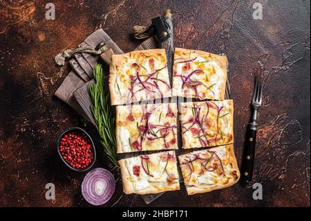 Tarte flamandes avec fromage à la crème, bacon et oignons.Flamkuchen de la région Alsace.Arrière-plan sombre.Vue de dessus Banque D'Images