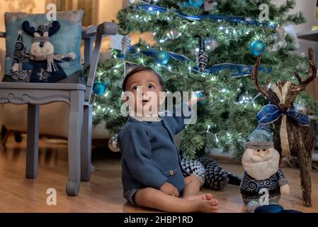 Beau petit garçon latin jouant avec la décoration de noël Banque D'Images