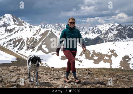 Bonne randonnée de randonneurs femelles avec chien sur la montagne contre le ciel nuageux ciel Banque D'Images