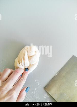 Le boulanger fait une queue de cochon de leur pâte pour le pain de la challah Banque D'Images