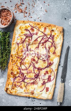 Tarte traditionnelle allemande de Flamkuchen avec jambon et oignon.Arrière-plan gris.Vue de dessus Banque D'Images