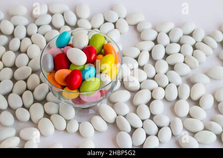 Bonbons traditionnels turcs aux amandes colorées enrobées dans le bol en verre transparent sur les autres amandes de couleur blanche. Image conceptuelle pour les célébrations. Banque D'Images