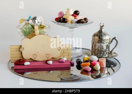 Cuisine turque traditionnelle, divers délices et bonbons sur plateau métallique avec tasse à café vintage et étiquette vierge en bois pour tout texte Banque D'Images