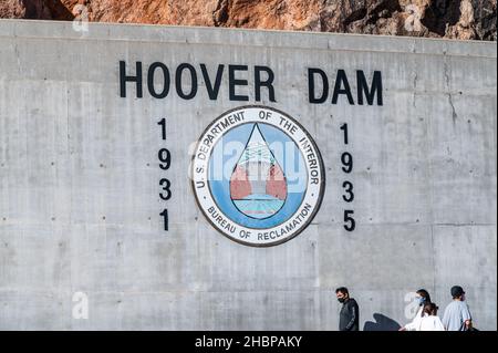 Boulder City, Nevada, Etats-Unis - 28 novembre 2021 : panneau du barrage Hoover avec le Bureau de la récupération du sceau, les gens marchent à côté Banque D'Images