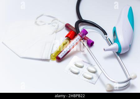 Microbiologiste avec un tube d'échantillon de sang biologique contaminé par le coronavirus portant l'étiquette Covid-19 sur fond blanc Banque D'Images