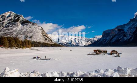 Belles vues d'hiver dans le parc national Banff Alberta Canada.Patinage et pêche sur le lac gelé Minnewanka. Banque D'Images