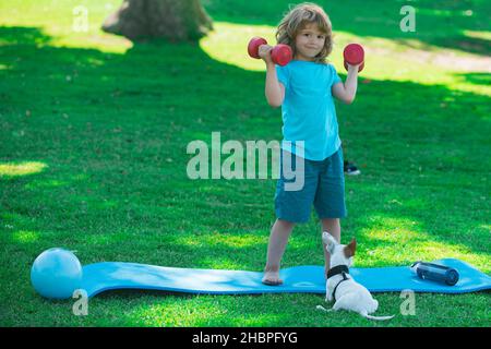 Enfant sportif avec haltères.Sport et fitness, santé et énergie pour les enfants.Un mode de vie sain pour les enfants.Gai garçon faire des exercices avec des haltères.Sport Banque D'Images