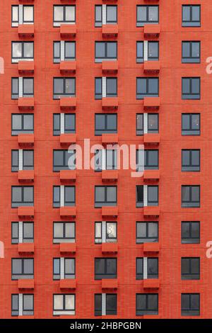 Fragment d'un mur rouge d'une maison avec fenêtres et balcons.Peut être utilisé comme arrière-plan. Banque D'Images