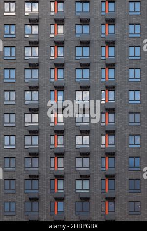 Fragment d'un mur gris d'une maison avec fenêtres et balcons.Peut être utilisé comme arrière-plan. Banque D'Images