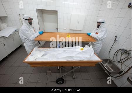 Ulm, Allemagne.10th décembre 2021.Deux employés de la maison funéraire First Ulm ferment le cercueil d'une personne décédée avec Covid-19 et qui est couché dans un sac de corps.Credit: Marijan Murat/dpa/Alamy Live News Banque D'Images