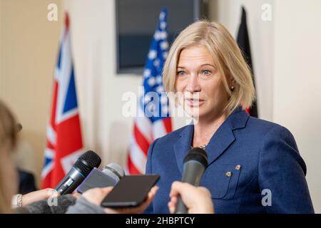 Femme mature députée en costume élégant parlant dans les microphones des journalistes à la conférence de presse après un événement politique Banque D'Images