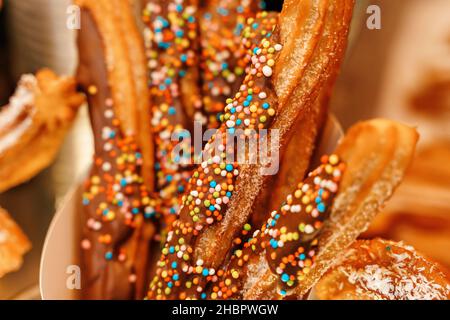 Gaufres churos dans la main sur le marché de la neige d'hiver.Churros cuisine mexicaine de rue dessert.Bonbons fast-food, biscuits de Noël.Photo de haute qualité Banque D'Images