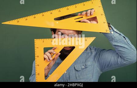 homme dont la taille est mesurée à l'aide d'un outil mathématique de règle triangulaire, disciplines de tige d'école Banque D'Images