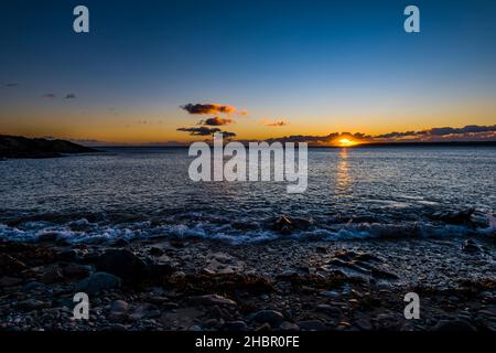 Coucher de soleil au-dessous des nuages au-dessus de la baie de Mount's depuis Trevean Cove près de Penzance, Cornwall, Royaume-Uni Banque D'Images