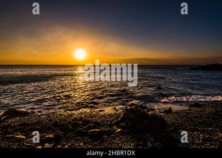 Coucher de soleil sur la baie de Mount's depuis Trevean Cove près de Penzance, Cornwall, Royaume-Uni Banque D'Images