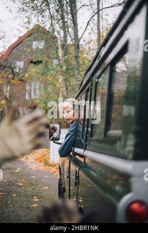 Femme mature qui regarde hors du véhicule utilitaire sport Banque D'Images